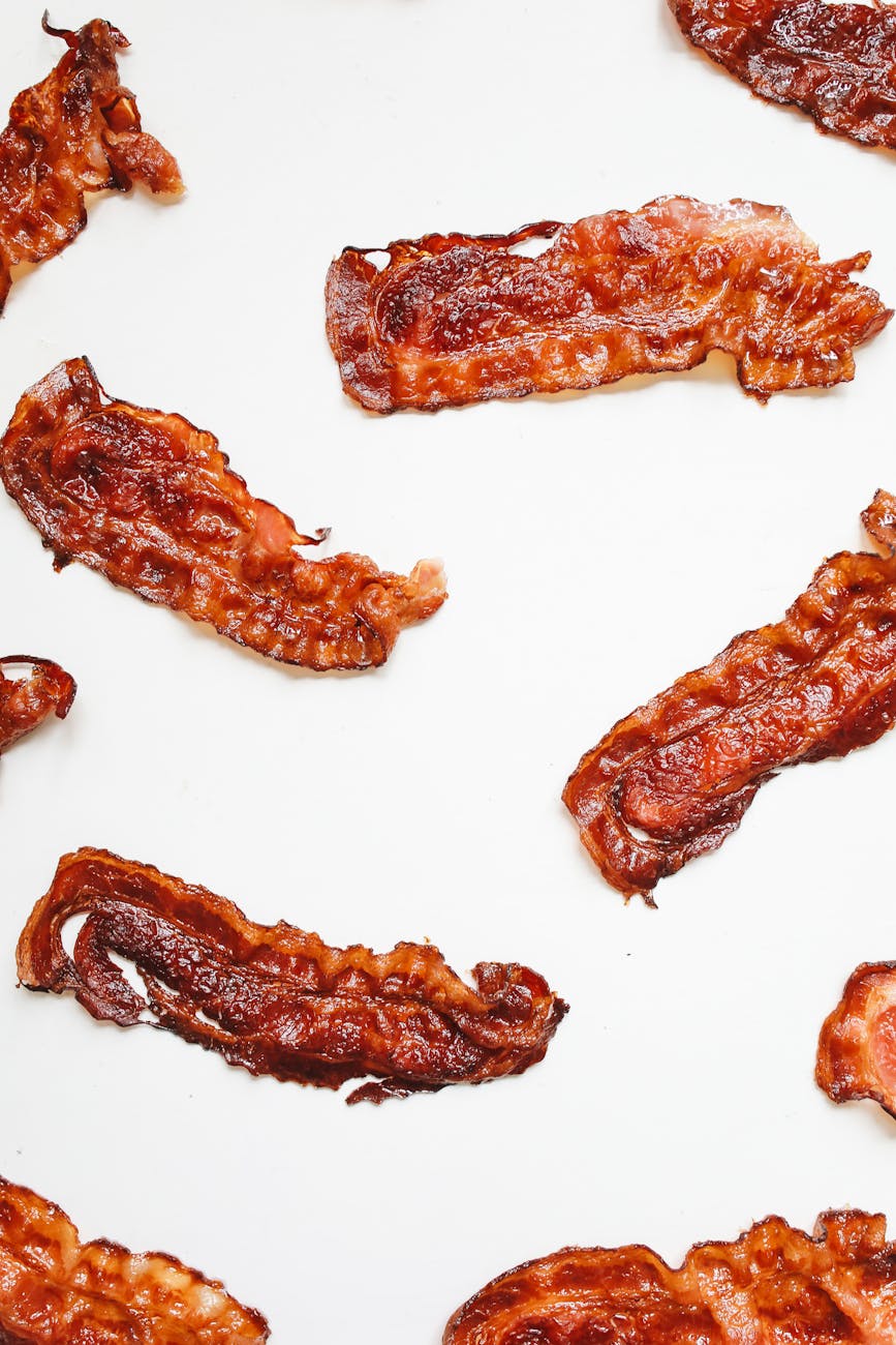 brown bacon strips on white surface