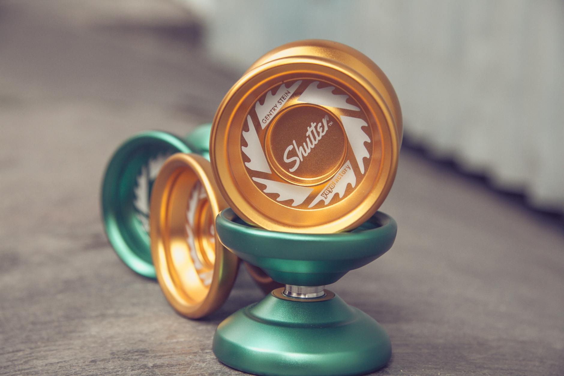 green and gold yo yos on gray floor