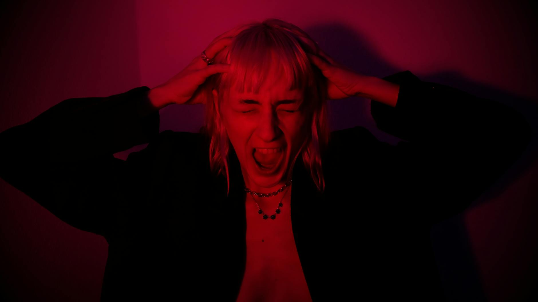 expressive woman screaming on a dark room