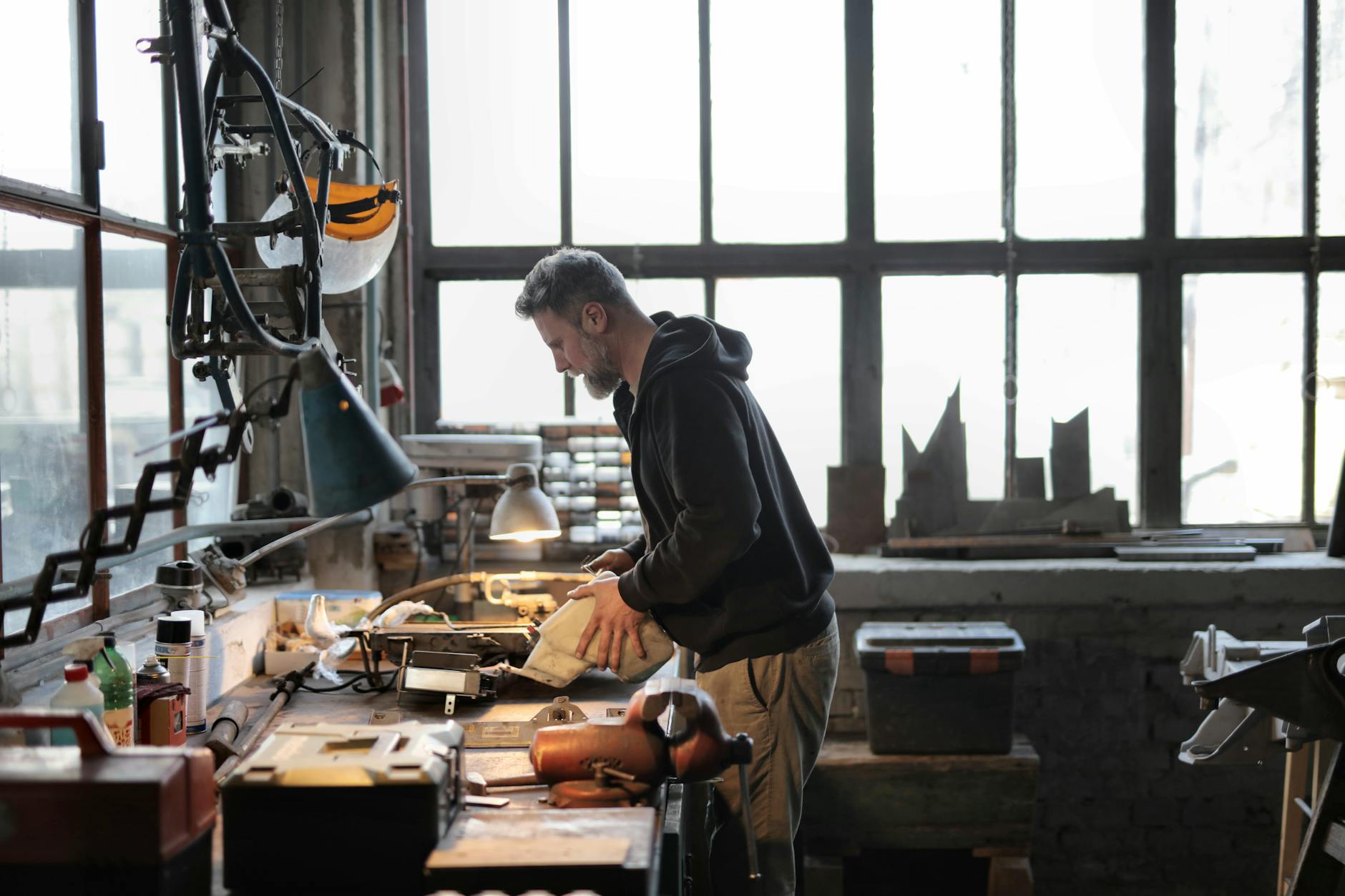 male master working with metal tools in garage